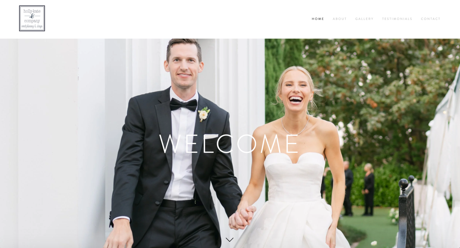 A bride and groom smiling, walking towards their wedding party holding hands.